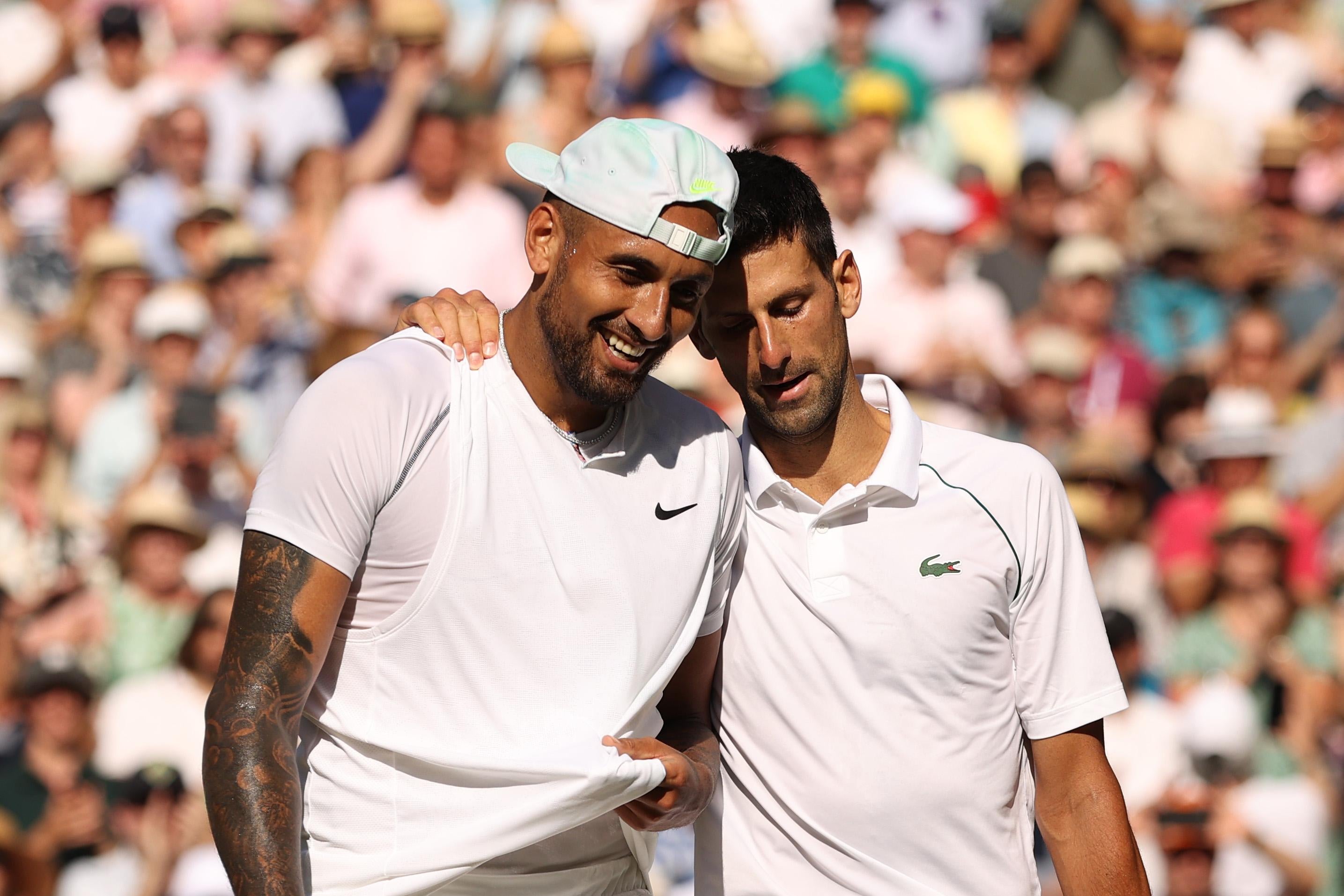 Novak Djokovic puts his arm around Nick Kyrgios' shoulder.