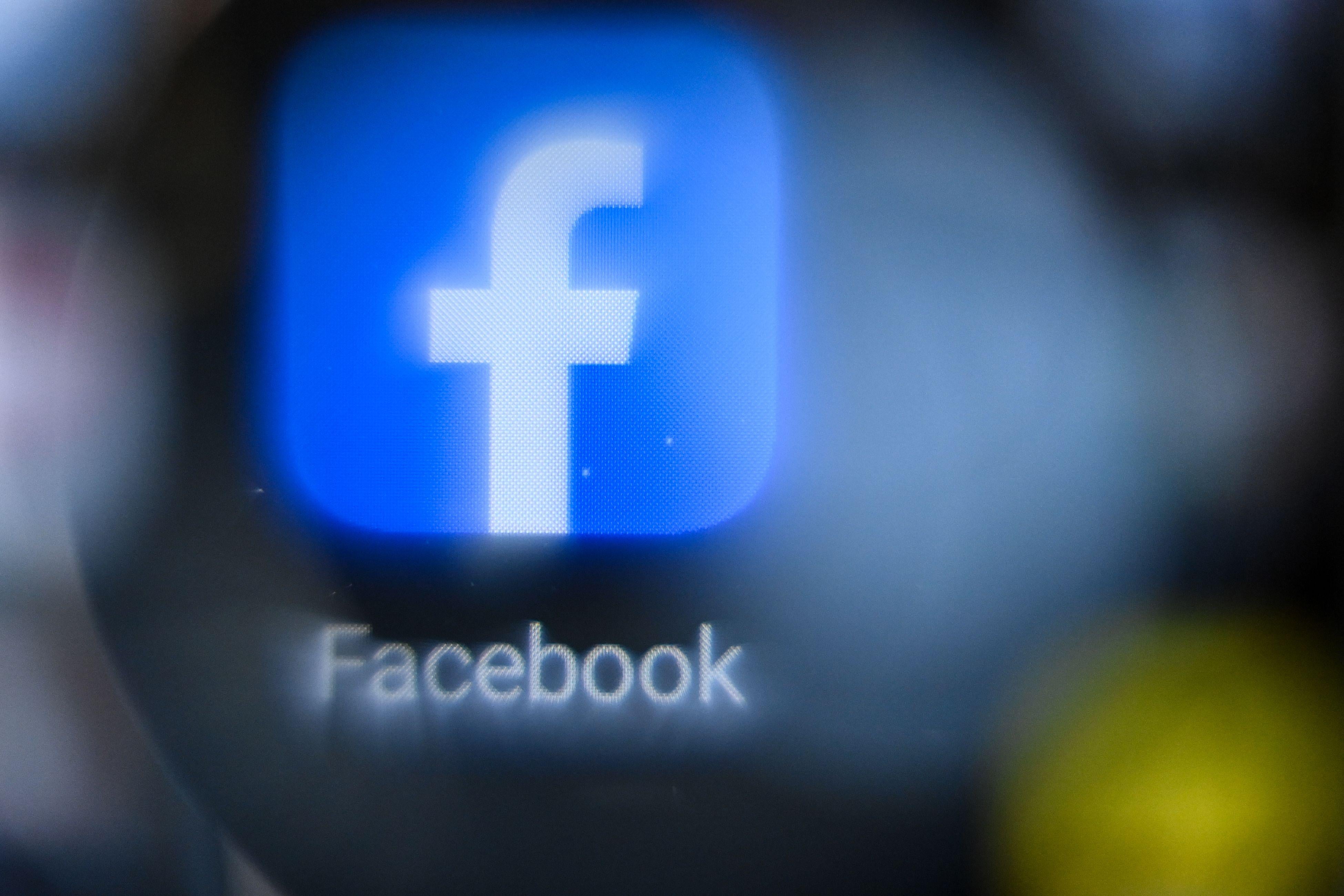 A blurry Facebook logo on a smartphone screen.