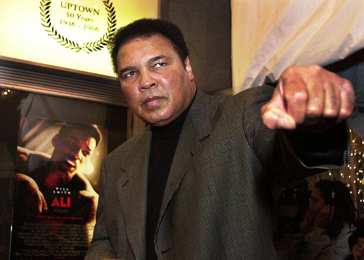 Former heavyweight boxing champ Muhammad Ali throws a punch as he poses for photographers on his arrival at the Uptown Theatre in Washington, DC, for the premiere of "Ali", the screen biography of his life, 17 December, 2001.