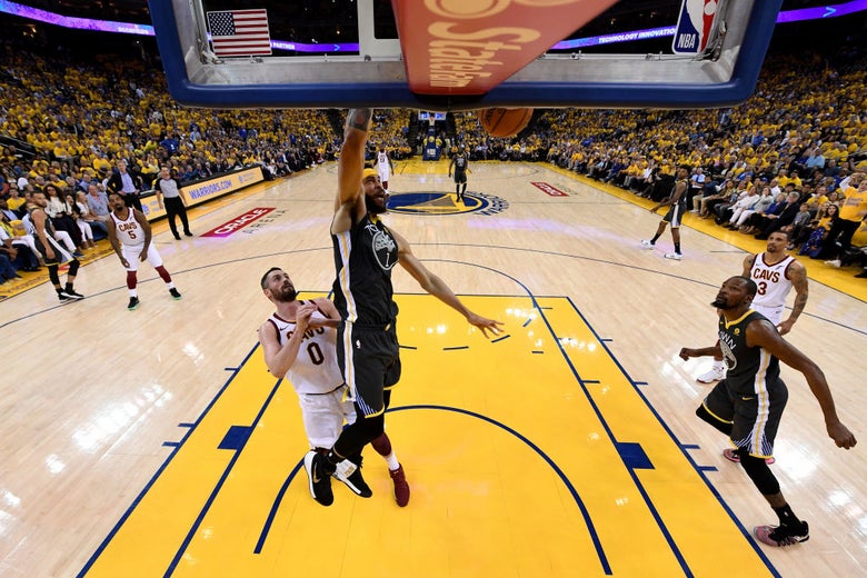 JaVale McGee of the Warriors dunks while Kevin Love watches.