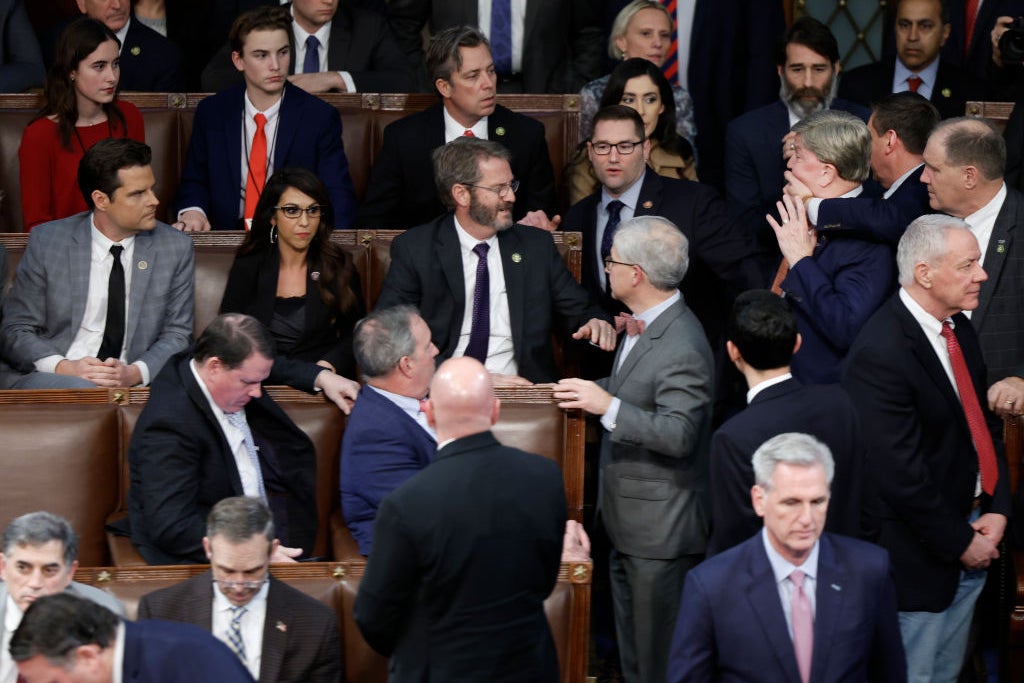 A side view of the incident, with Hudson's hand now covering Rogers' mouth and Rogers leaning back away from Gaetz.