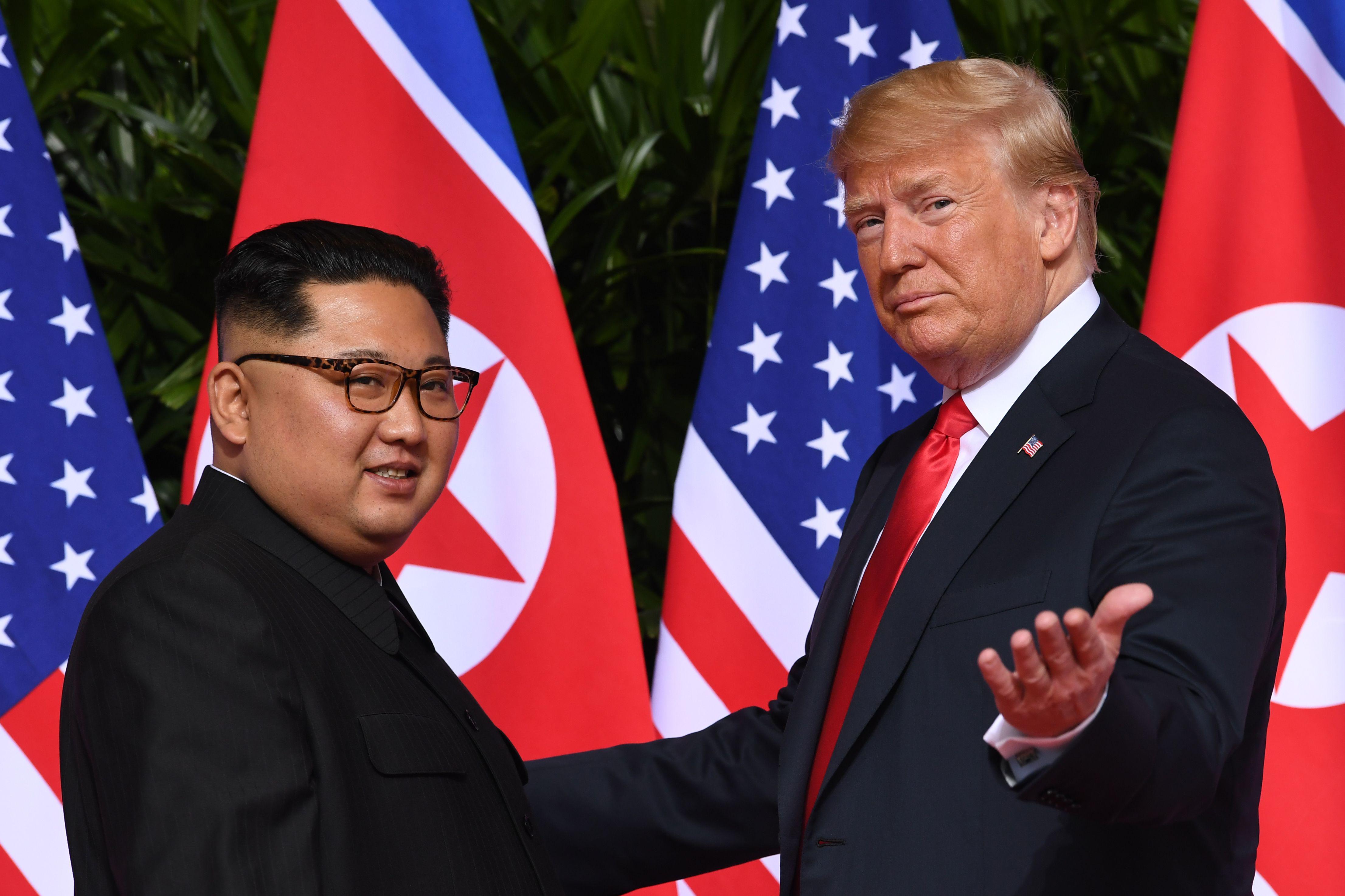 President Donald Trump gestures as he meets with North Korea's leader Kim Jong Un at the start of their historic US-North Korea summit, at the Capella Hotel on Sentosa island in Singapore on June 12, 2018. 