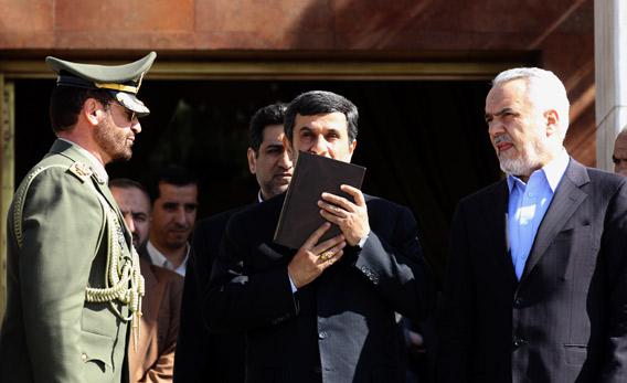 Iranian President Mahmoud Ahmadinejad kisses the Koran.