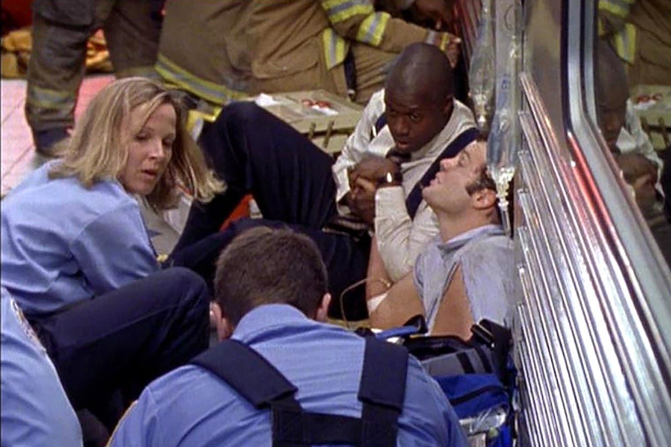 EMTs examine a trapped subway passenger at the scene of a crash.