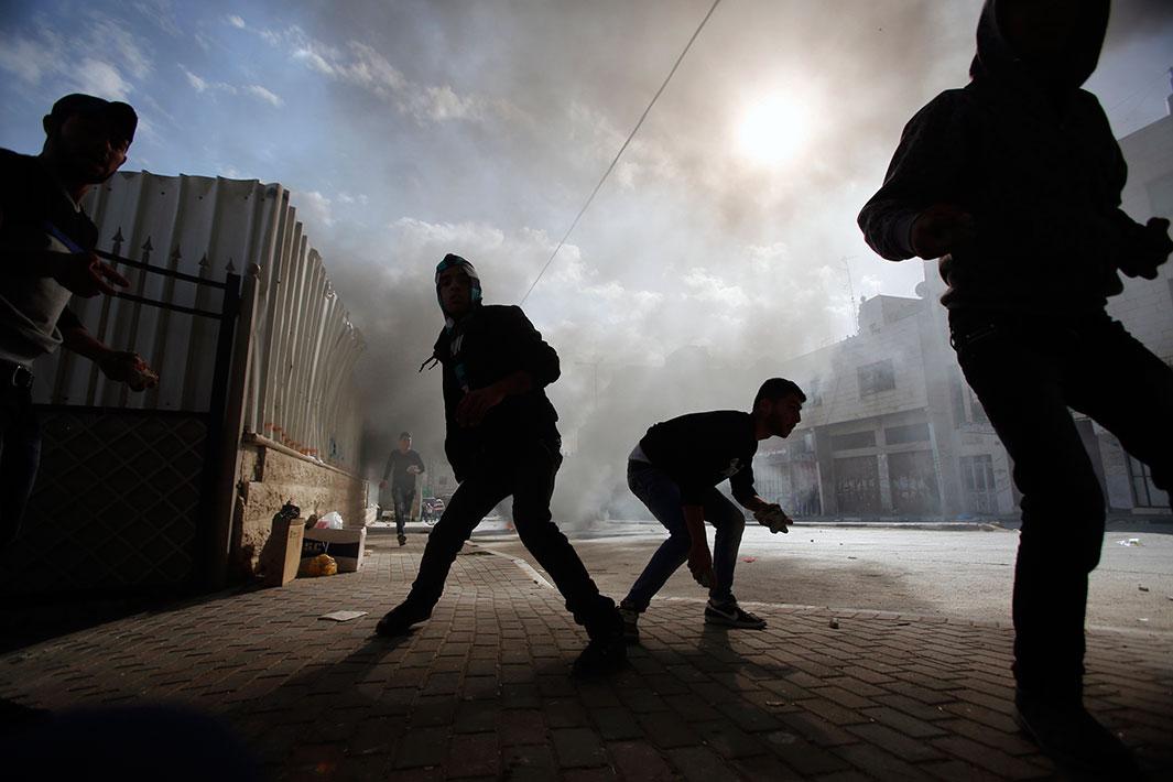 Palestinian protesters prepare to throw stones at Israeli army soldiers during clashes following an anti-Israel demonstration in solidarity with al-Aqsa mosque, in the West Bank city of Hebron on Nov. 14, 2014. Israel and the Palestinians have pledged to take concrete steps to calm tensions around Jerusalem's holiest site, U.S. Secretary of State John Kerry said on Thursday after talks in the Jordanian capital. Violence has flared in recent weeks over the compound, revered by Muslims as Noble Sanctuary, where al-Aqsa mosque stands, and by Jews as the Temple Mount, where their biblical temples once stood. 
