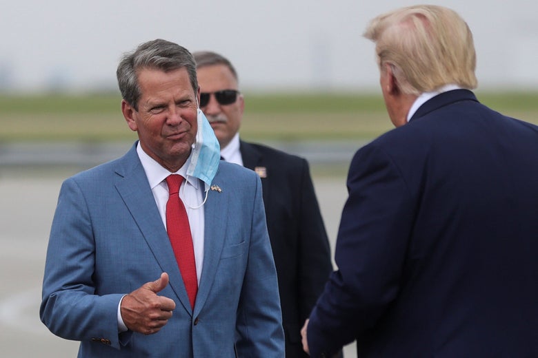 Kemp, with a surgical mask dangling under his chin, gives a thumbs-up to Trump