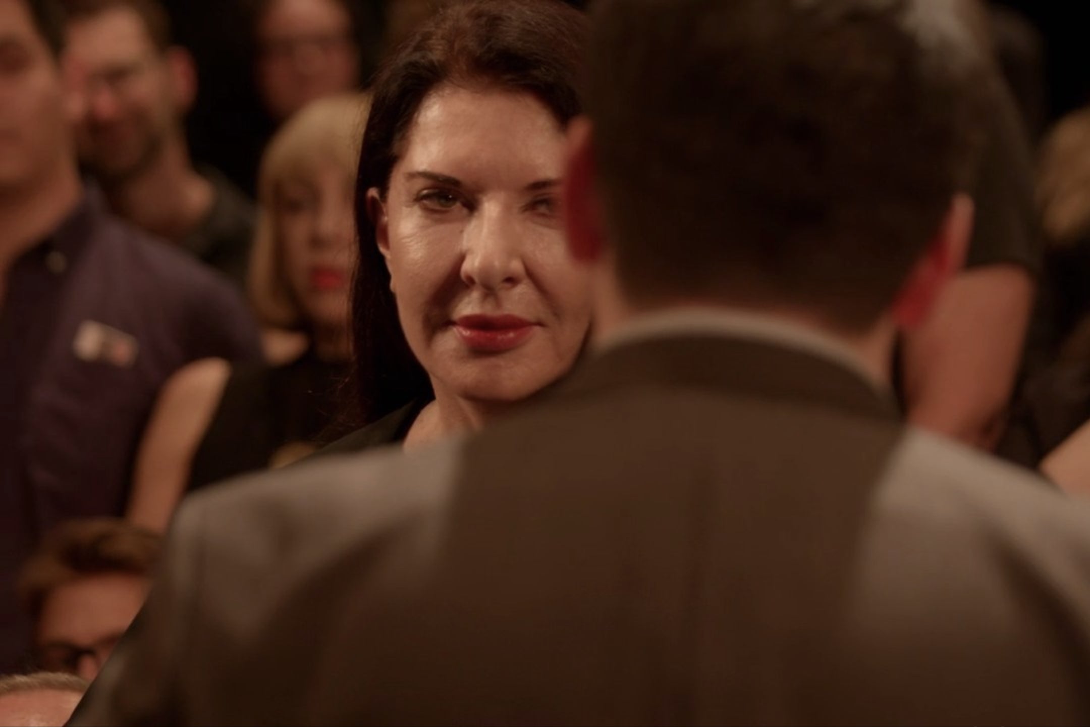 Maria Abramovic at In and of Itself, obscured by the back of a man standing in front of her.