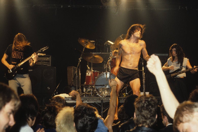 Black Flag performs onstage in front of a crowd.