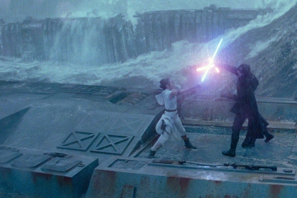 Rey and Kylo Ren fight with lightsabers atop a metal structure surrounded by waves.