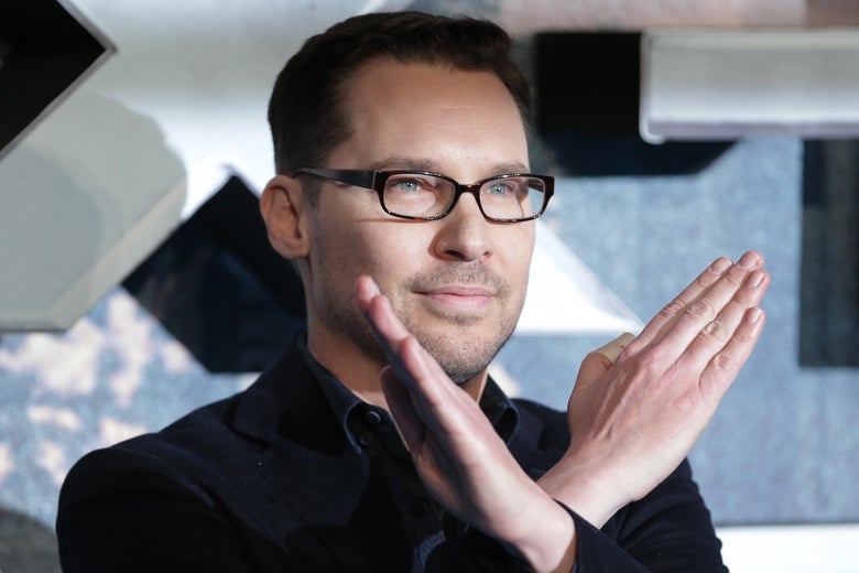 Bryan Singer with his arms in the shape of a letter X, crossed at the wrists.