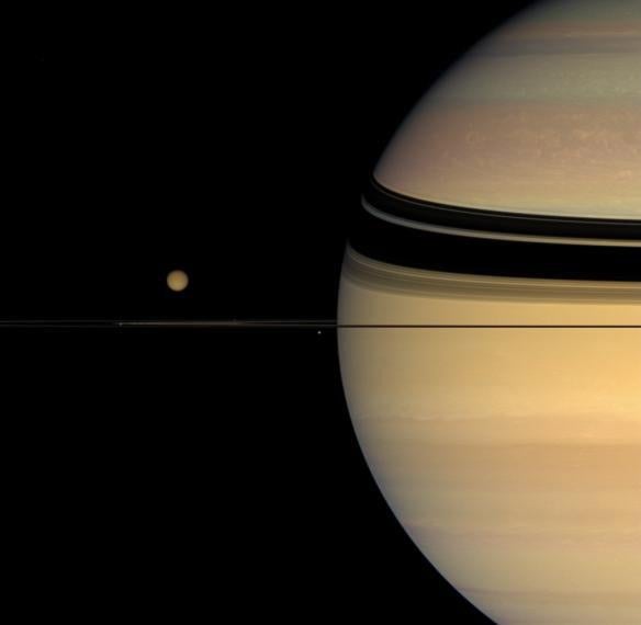 Four moons huddle near Saturn's multihued disk.