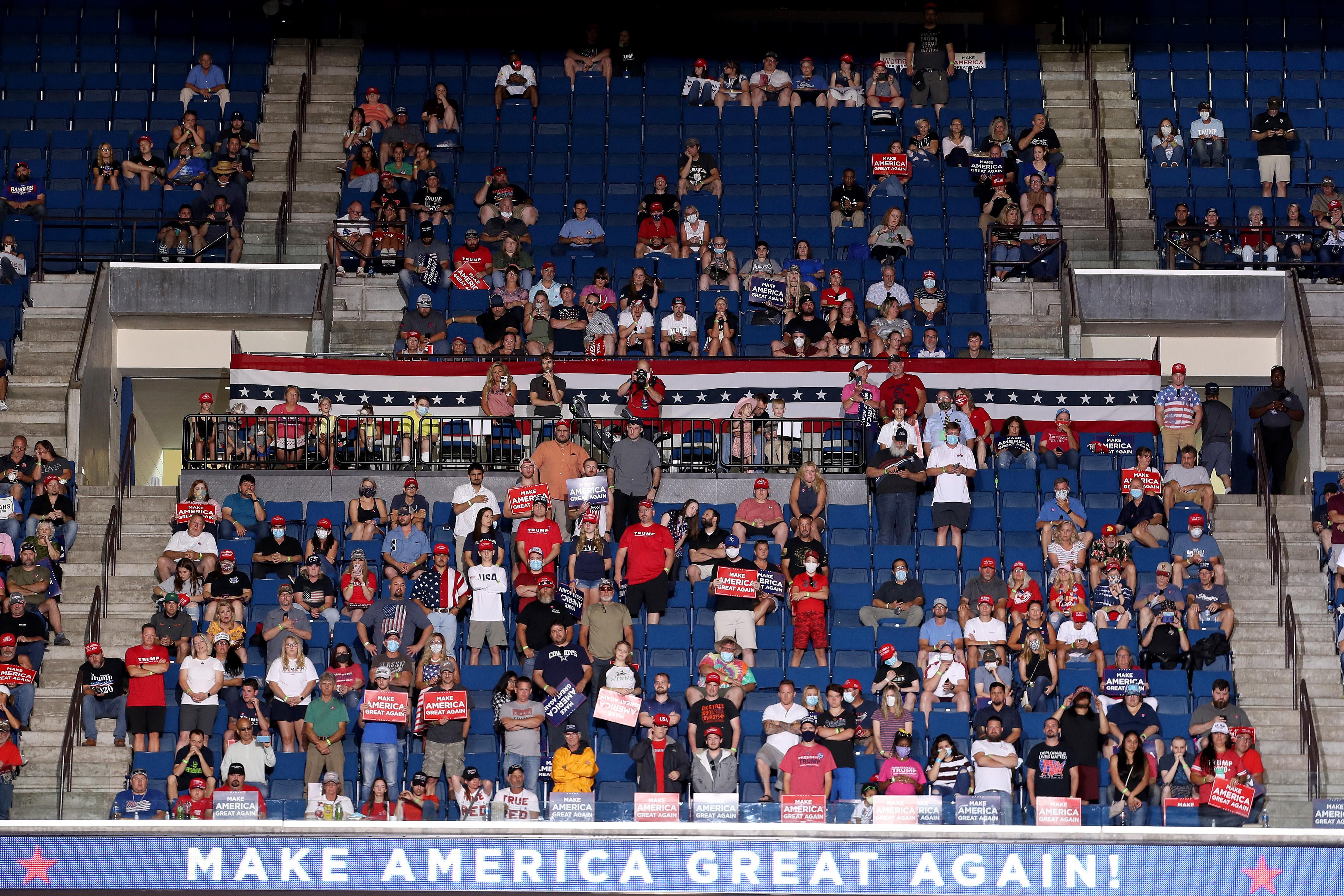 Trump supporters sit in the stands. There are many empty seats.