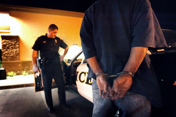Tucson Police Officer Angel Ramirez arrests a man for trespassing May 29, 2010 in Tucson, Arizona.