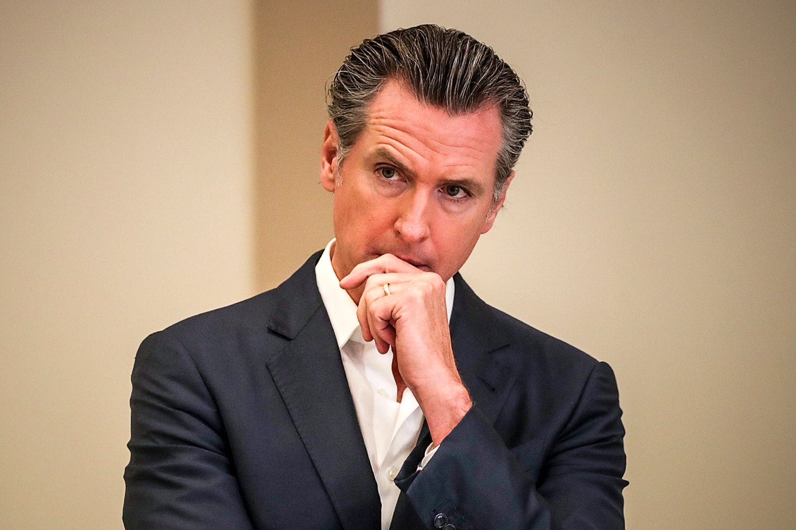Gov. Gavin Newsom standing with a pensive expression.