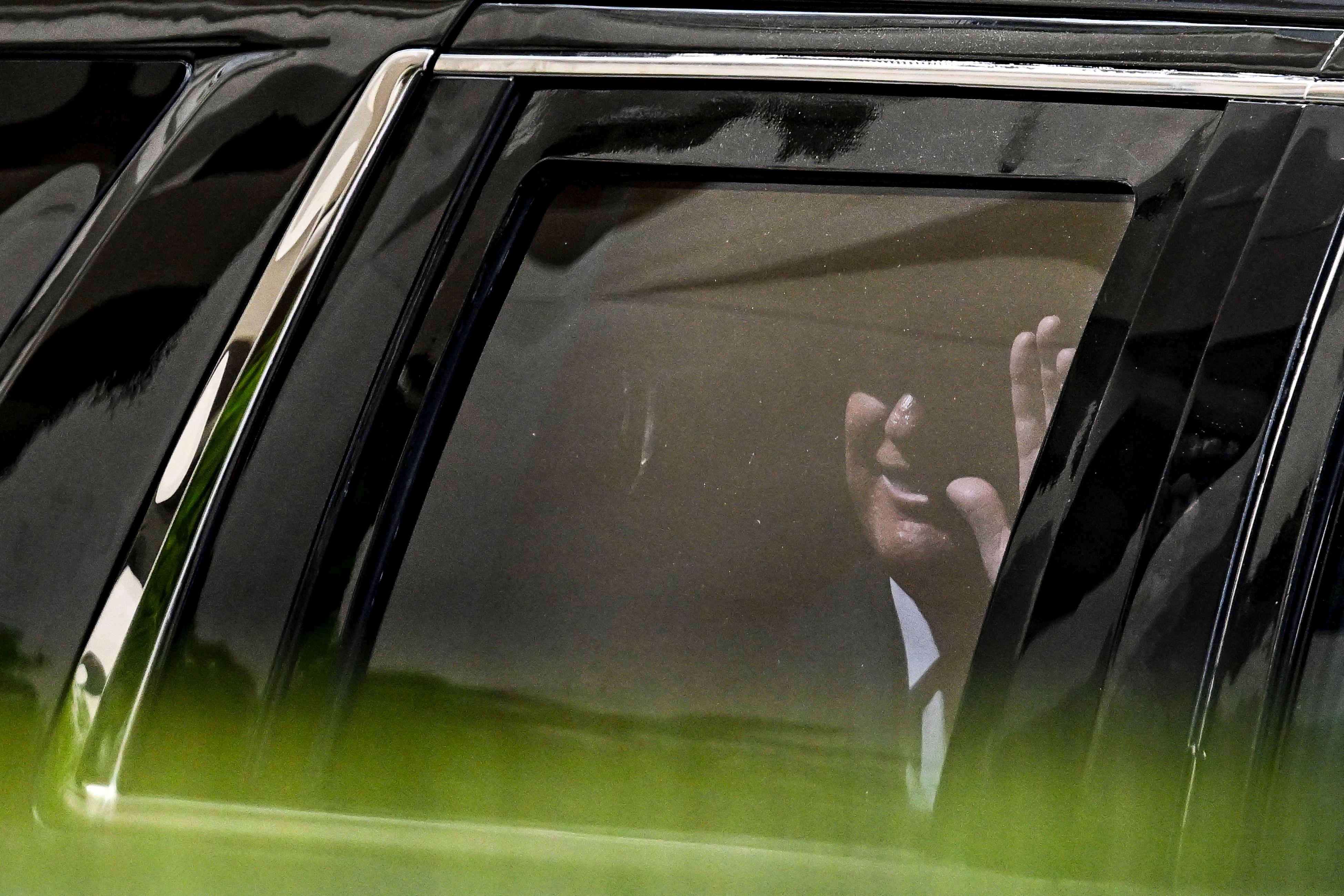 Trump waving through a car window