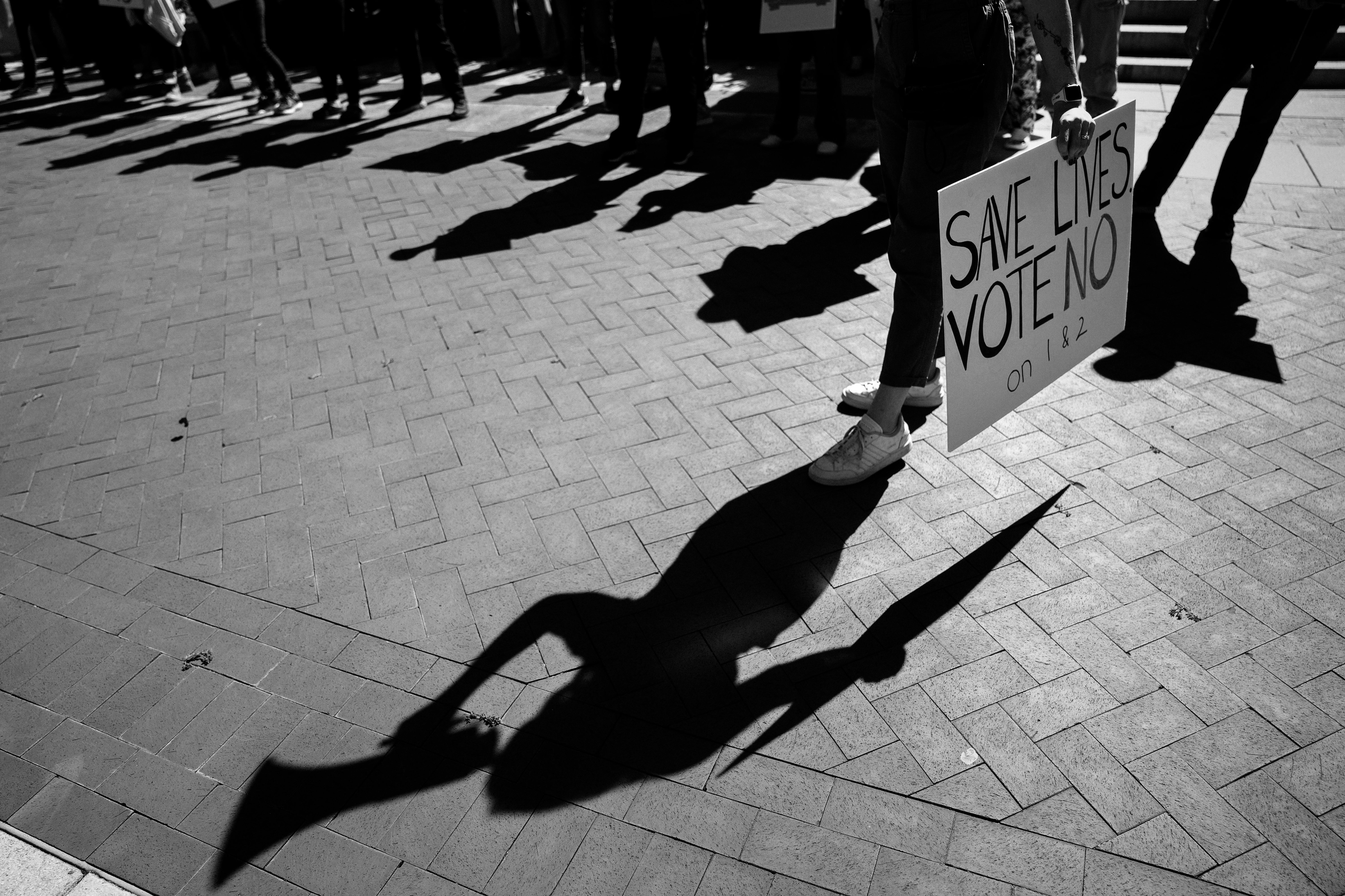 A black-and-white photo of the shadows of anti-abortion protesters in Kentucky before the 2022 midterms election.