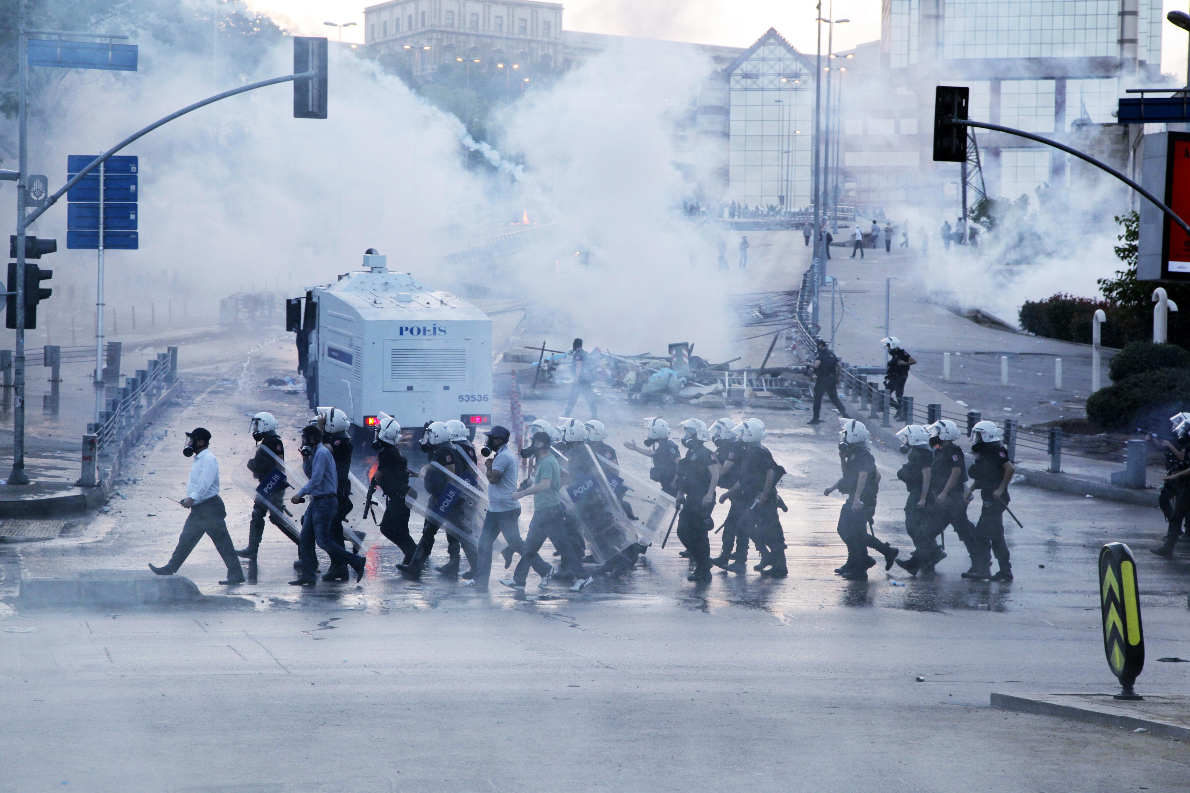 Turkish riot policemen head towards protestors in a street during clashes between Taksim and Besiktas in Istanbul on June 3, 2013.