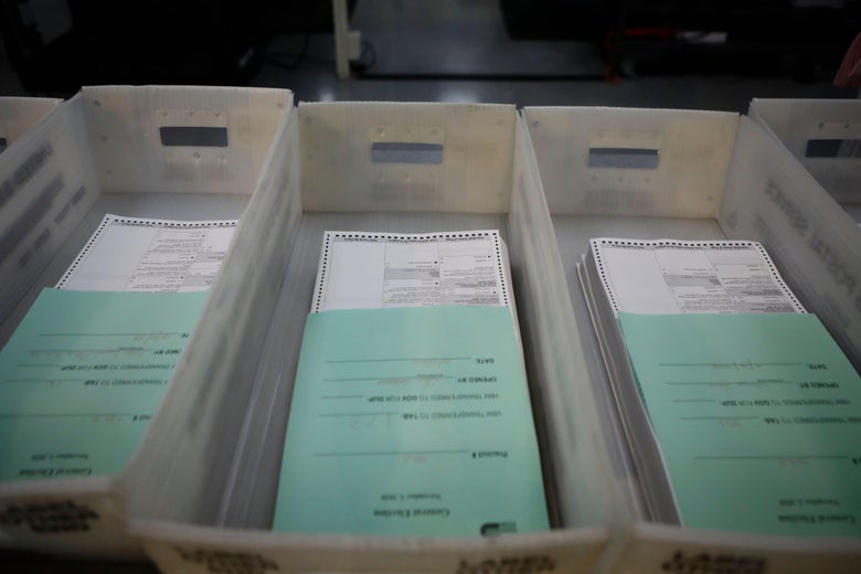 Three boxes of voting ballots are seen.