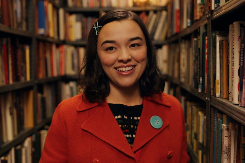 A young woman stands among bookshelves in the Strand