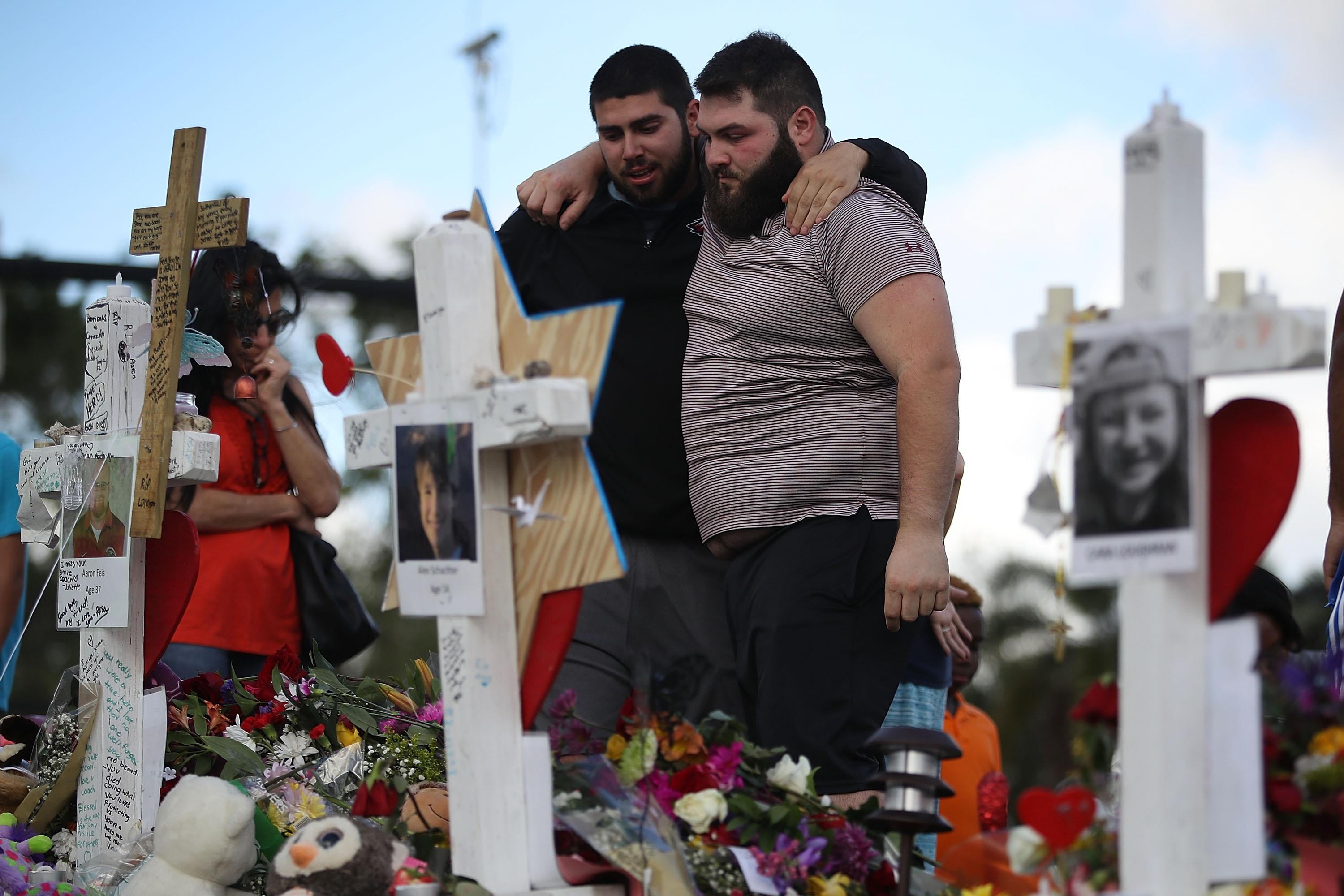 Max Bromberg hugs his brother Samuel Bromberg as they visit a makeshift memorial on February 19, 2018 in Parkland, Florida. 