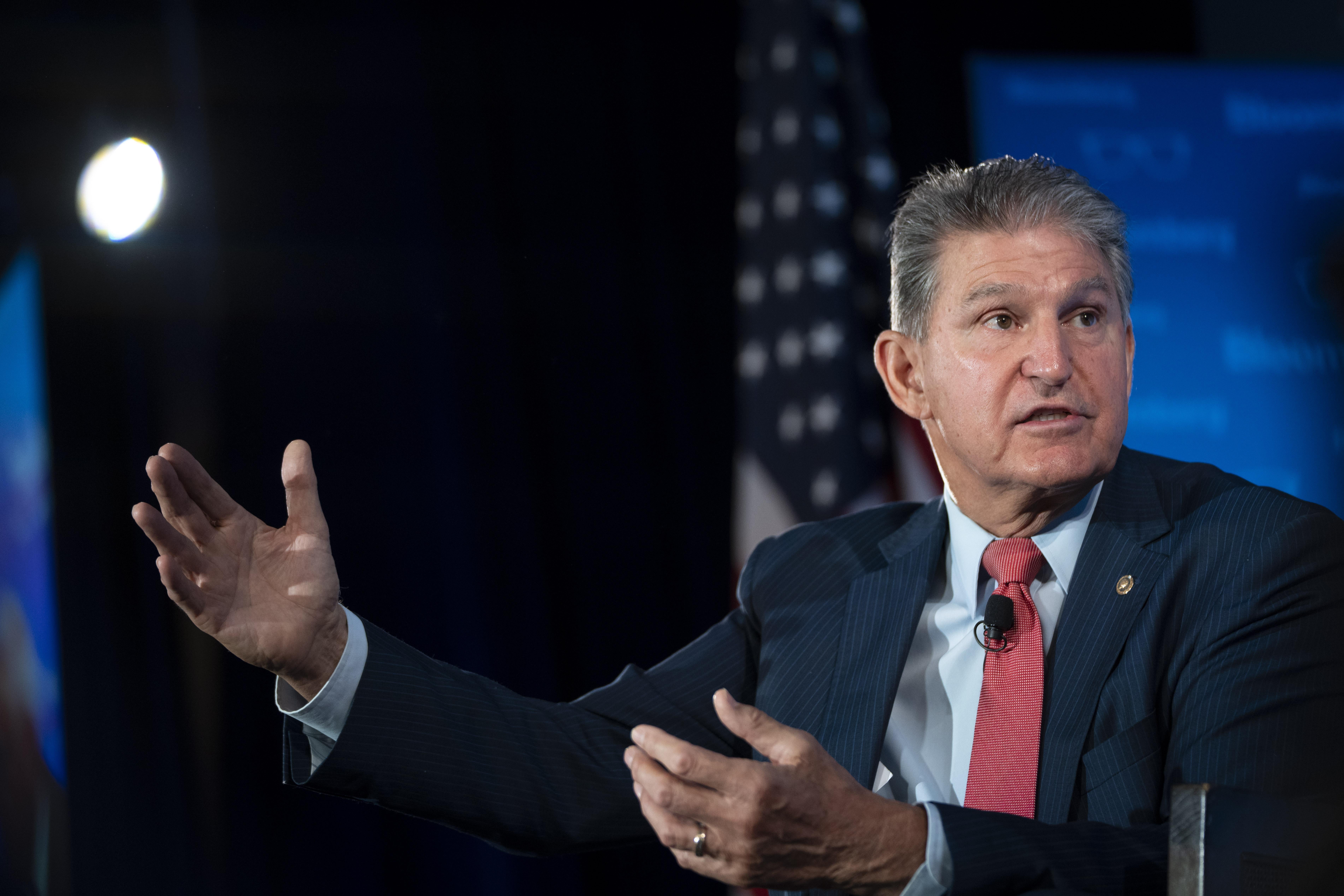 Manchin gestures with both hands as he speaks at an event