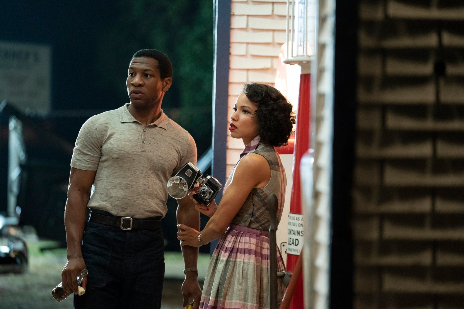 In a still from the show, Majors and Smollett look handsome, stylish, and afraid, at night at a roadside stop. Smollett is holding a camera.