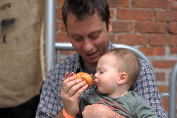 A father feeds his son a burger during the City Harvest Presents The Brooklyn Local at Tobacco Warehouse on September 17, 2011 in New York City.