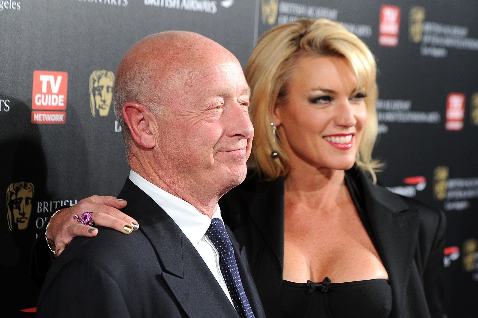 Tony Scott with his wife Donna W. Scott against a step-and-repeat smiling for cameras.
