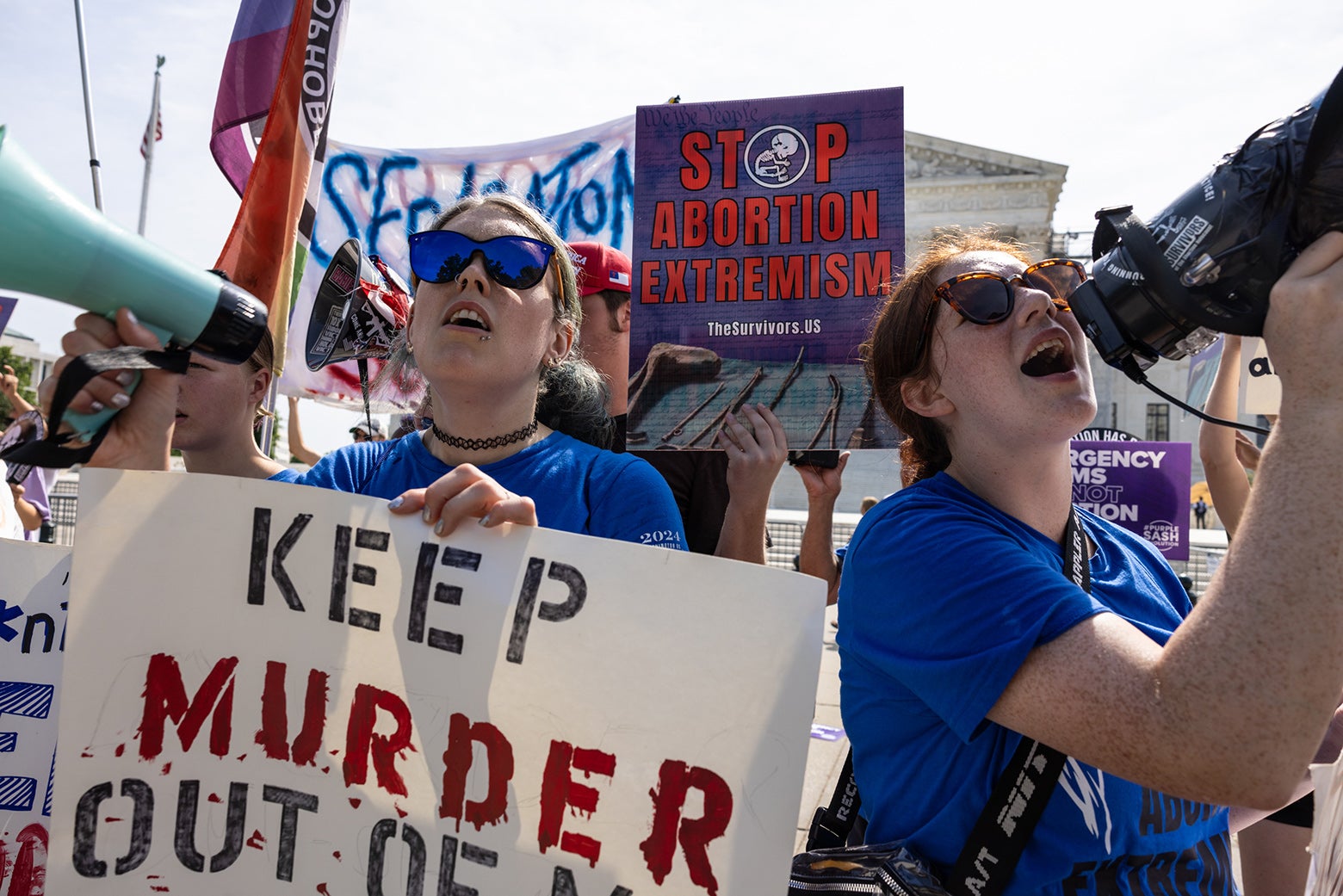 Anti-abortion demonstrators hold signs like "stop abortion extremism."