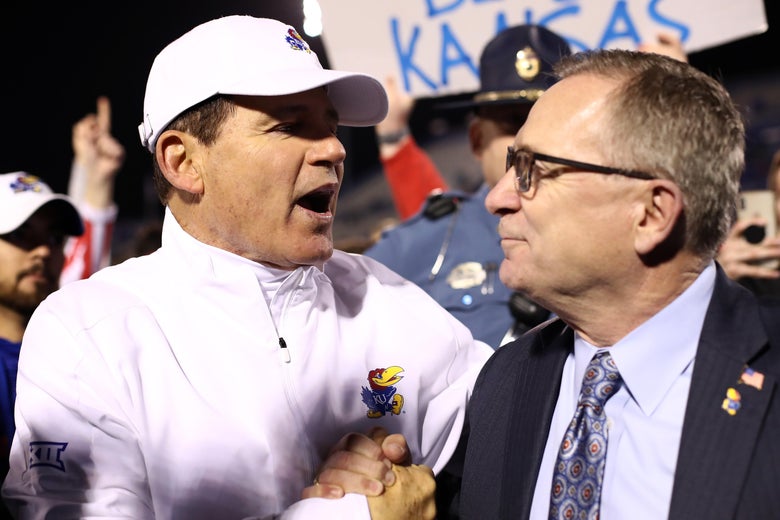 Les Miles of the Kansas Jayhawks and Athletic Director Jeff Long congratulate each other after a football game.