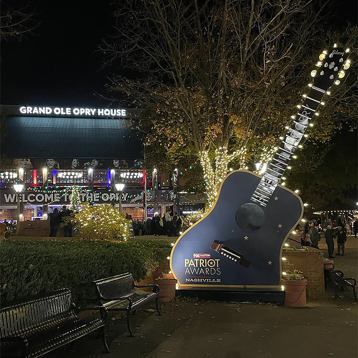 A photo of a big sign in the shape of a guitar that says "Patriot Awards" on it.