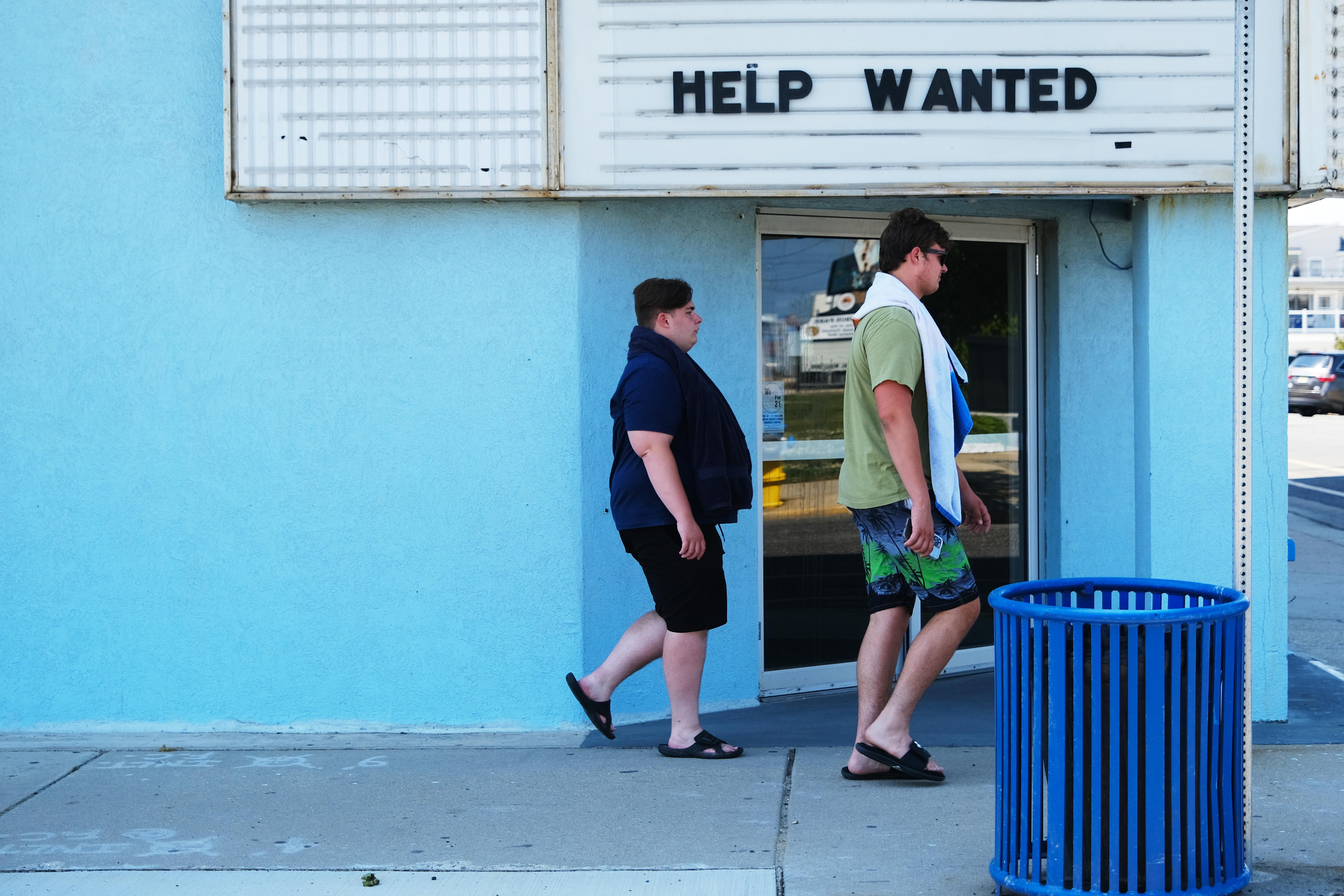A help wanted sign is displayed outside of a business near the boardwalk days before the Memorial Day weekend, the unofficial start of summer, in the shore community of Wildwood on May 27, 2021 in Wildwood, New Jersey. Wildwood, like many beach communities throughout the United States, is looking for a successful and busy summer season after staying mostly closed or partially open last summer due to Covid-19 restrictions. Many resort community retail businesses are also suffering from a shortage of labor as some workers are choosing to stay home and others have changed career paths.  (Photo by Spencer Platt/Getty Images)