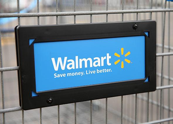 The Walmart logo is displayed on a shopping cart at a Walmart store.
