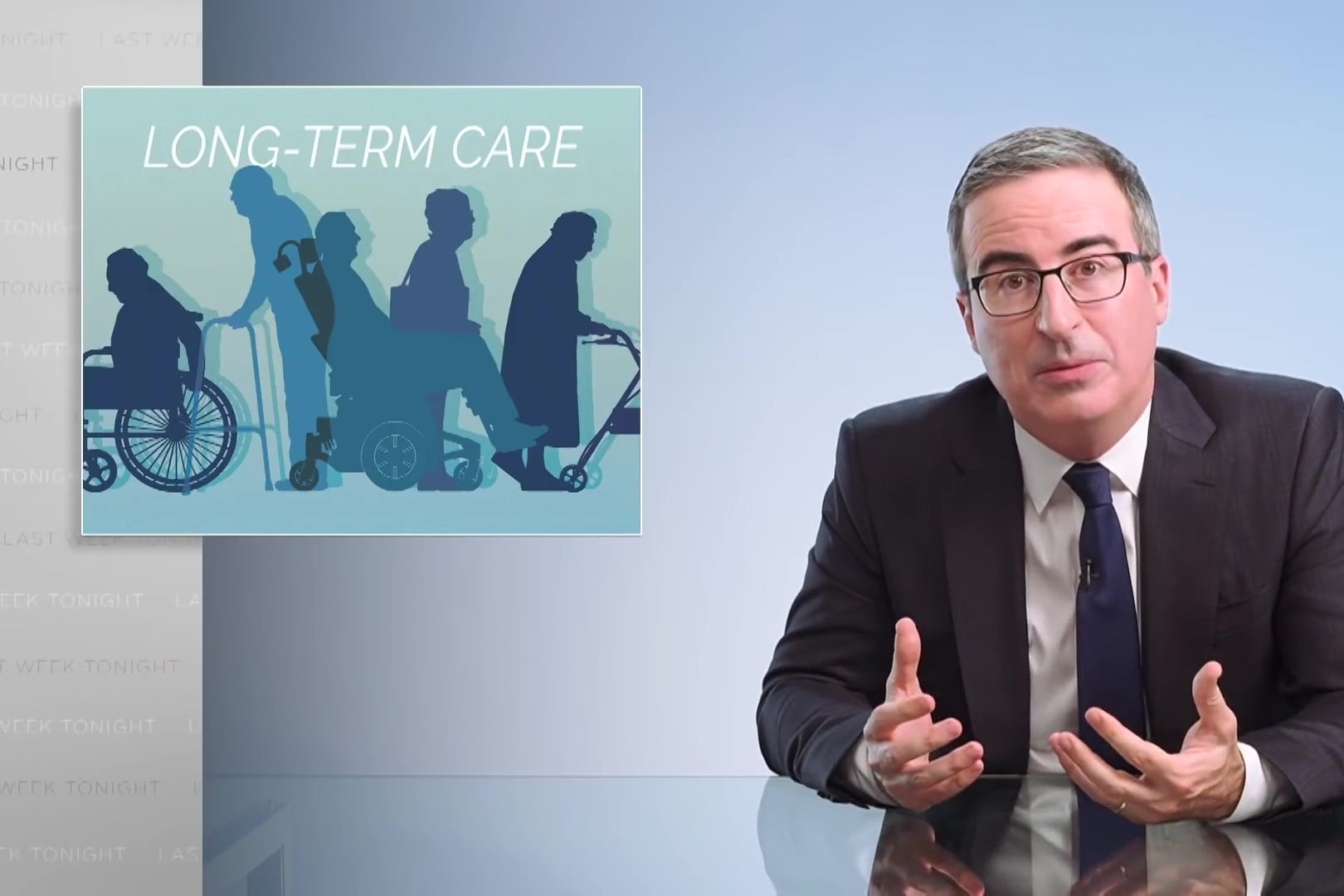 John Oliver sits at a glass desk in front of a sign reading "Long-Term Care."