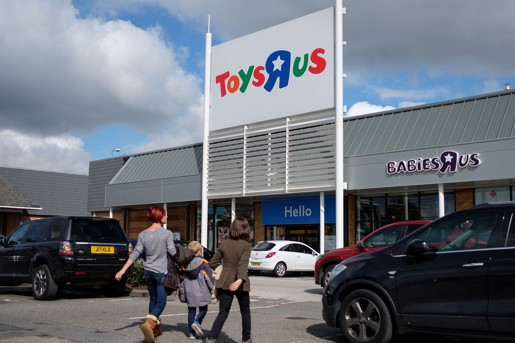Customers walk toward a branch of the toy store Toys R Us on Tuesday in Luton, England.