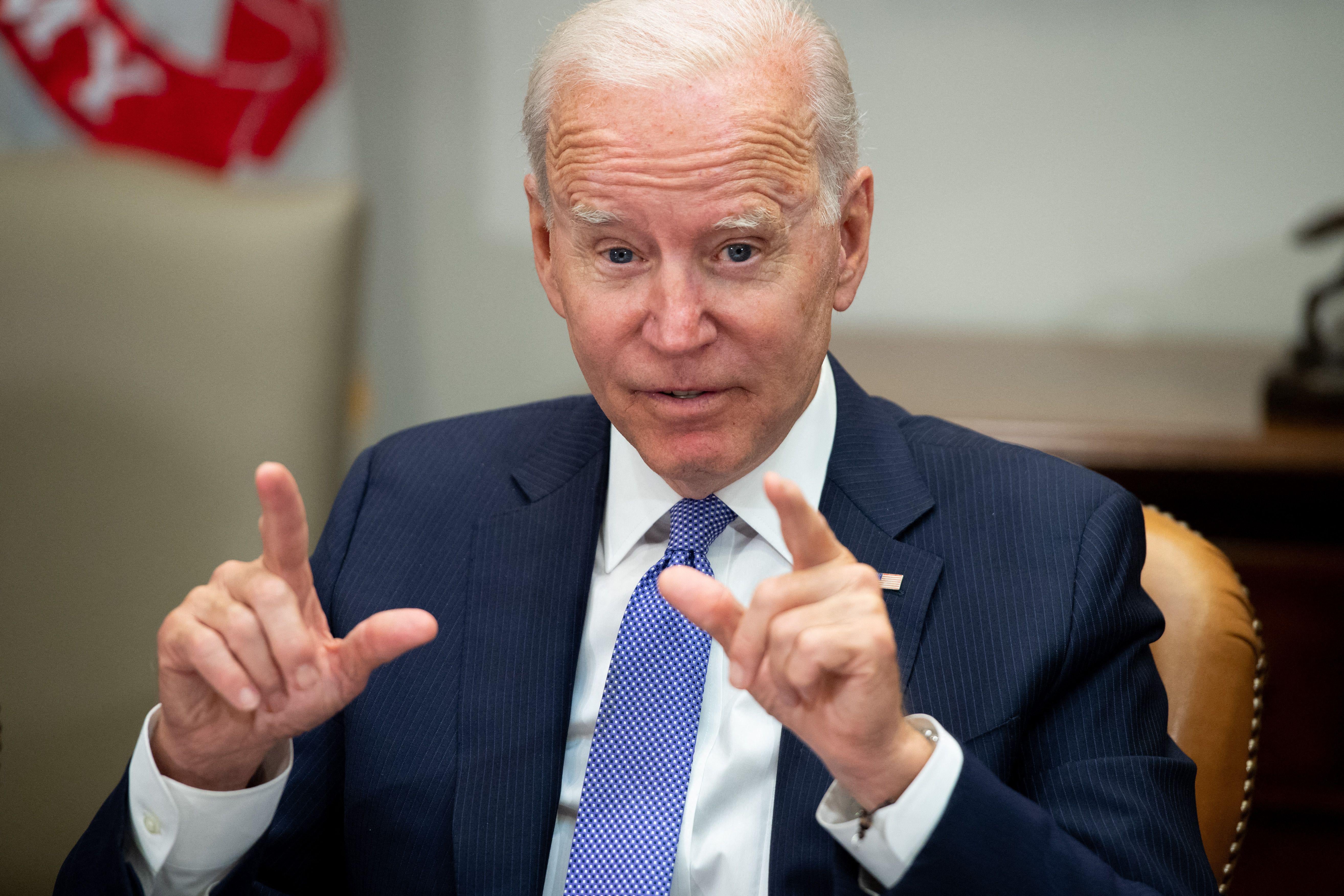 Biden sitting in the Roosevelt Room of the White House pointing both index fingers as he speaks