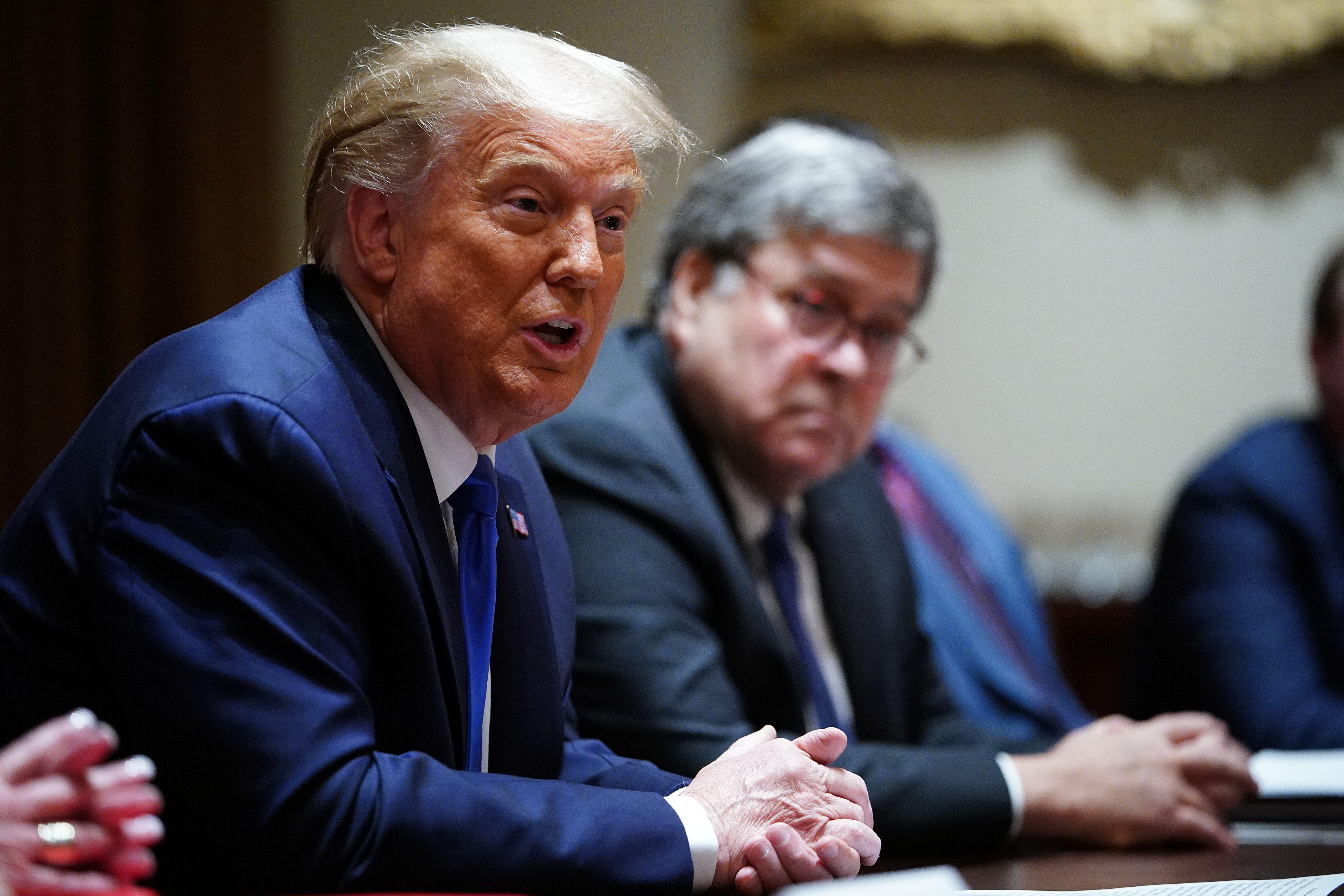 Trump, speaking, and Barr seated at a conference table with other government officials