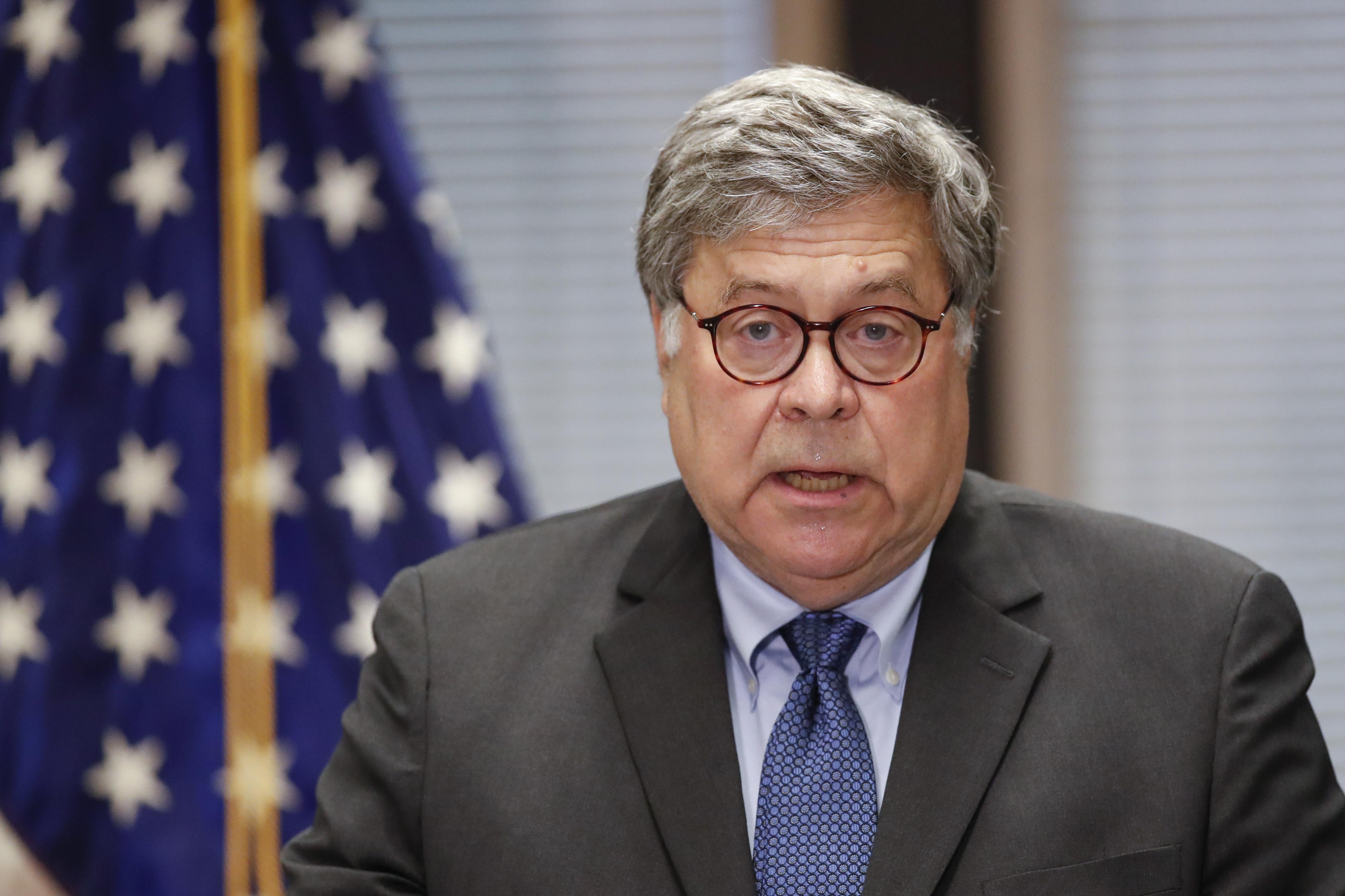William Barr speaks in front of an American flag.