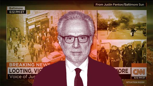 TV personality Wolf Blitzer attends the Soul Train Awards 2013 in November 2013 in Las Vegas, Nevada. Behind, CNN’s live feed of Baltimore on the Situation Room.