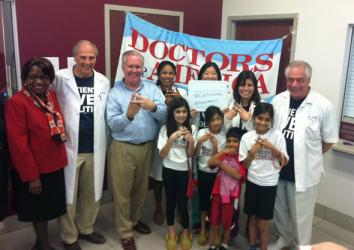 Tampa Mayor Bob Buckhorn, activists with Doctors for America, and health center staffers enrolling people in exchanges make the sign of a hashtag.