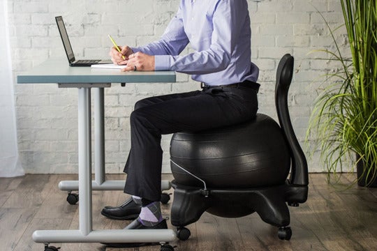 Man sitting in an exercise ball chair.
