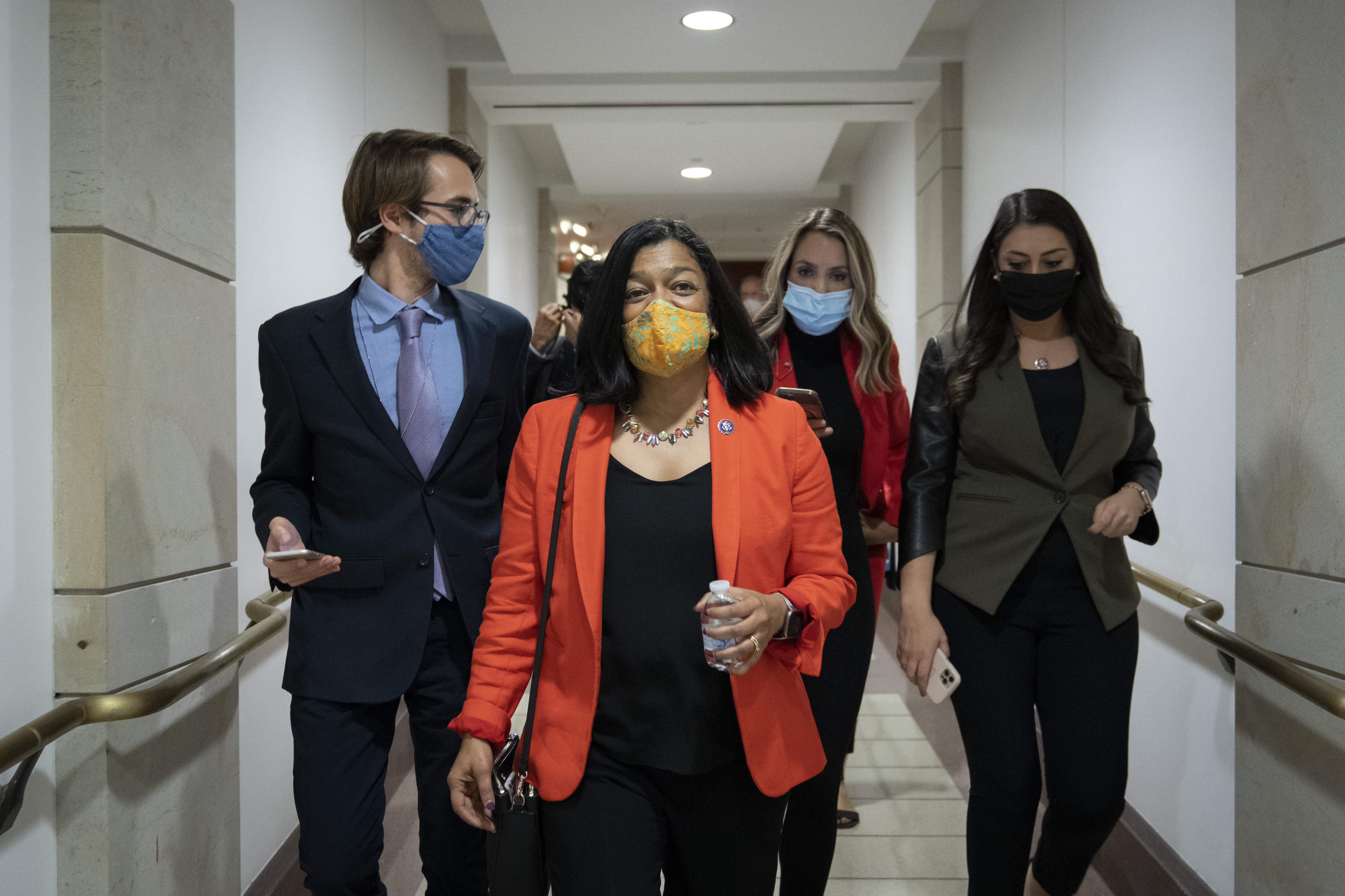 Jayapal walking down a hallway with a few other people