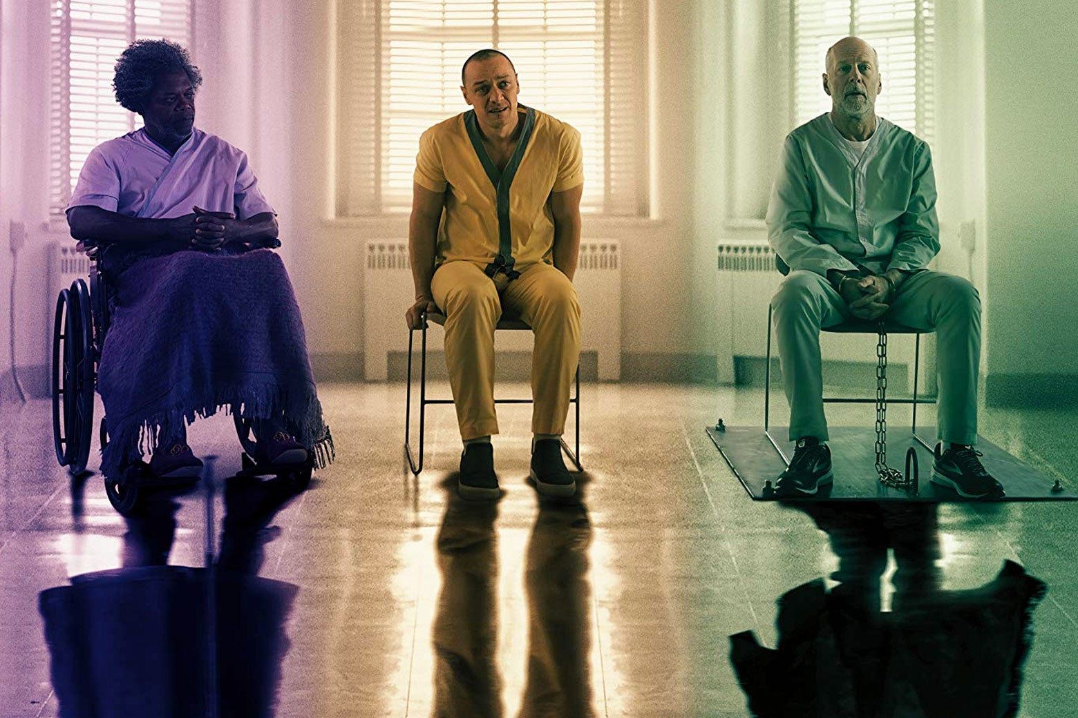 Bruce Willis, Samuel L. Jackson, and James McAvoy in Glass. The three men are seated next to each other in what appears to be a mental hospital.