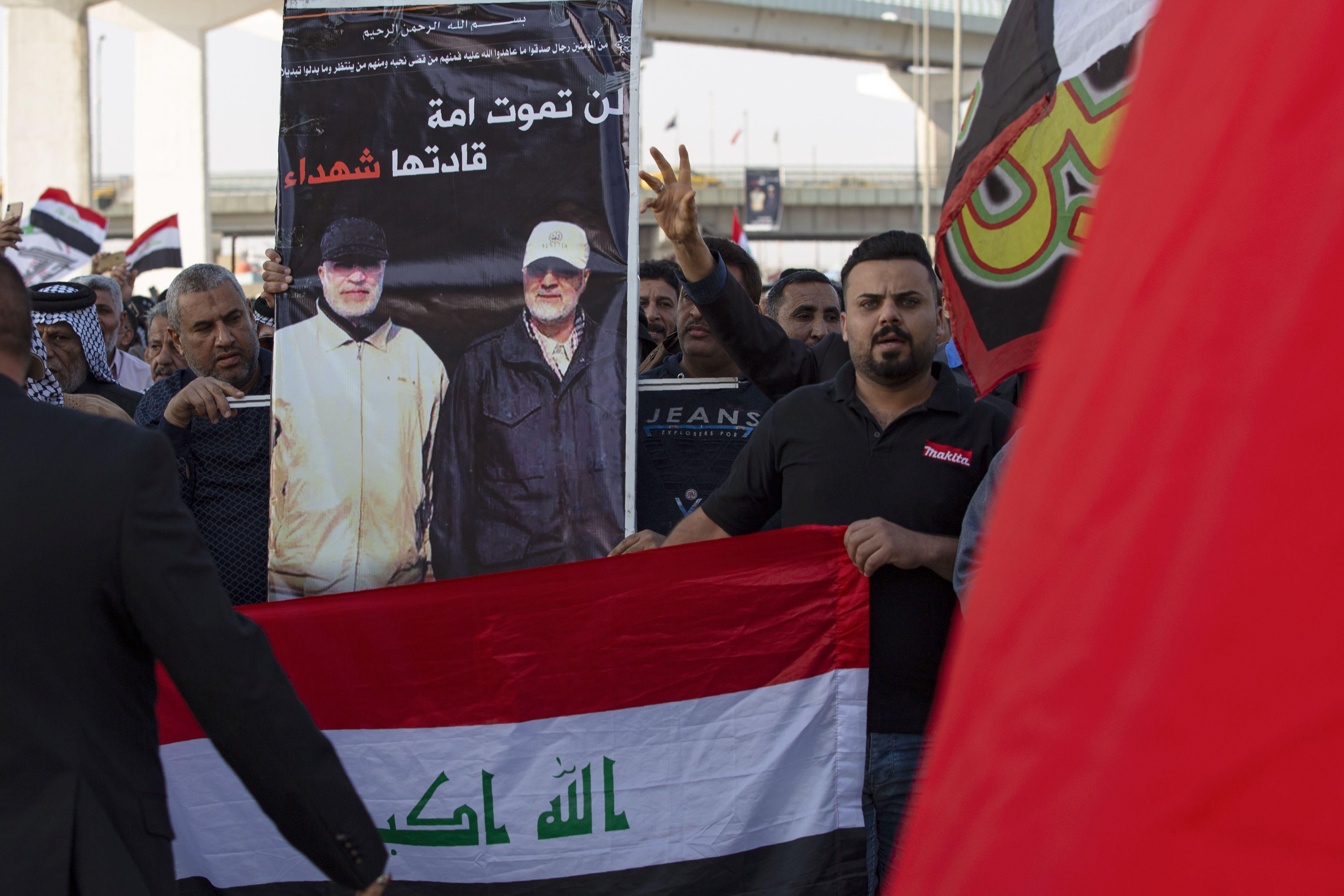 Iraqis carry a poster depicting Iran's Major General Qasem Soleimani (R) and senior Iraqi military figure Abu Mahdi al-Muhandis as they march in a symbolic funeral procession in the southern city of Basra, on January 5, 2020.