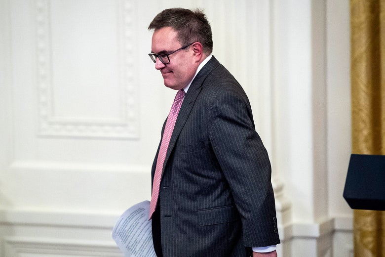 Andrew Wheeler smiles as he walks with some papers in his right hand