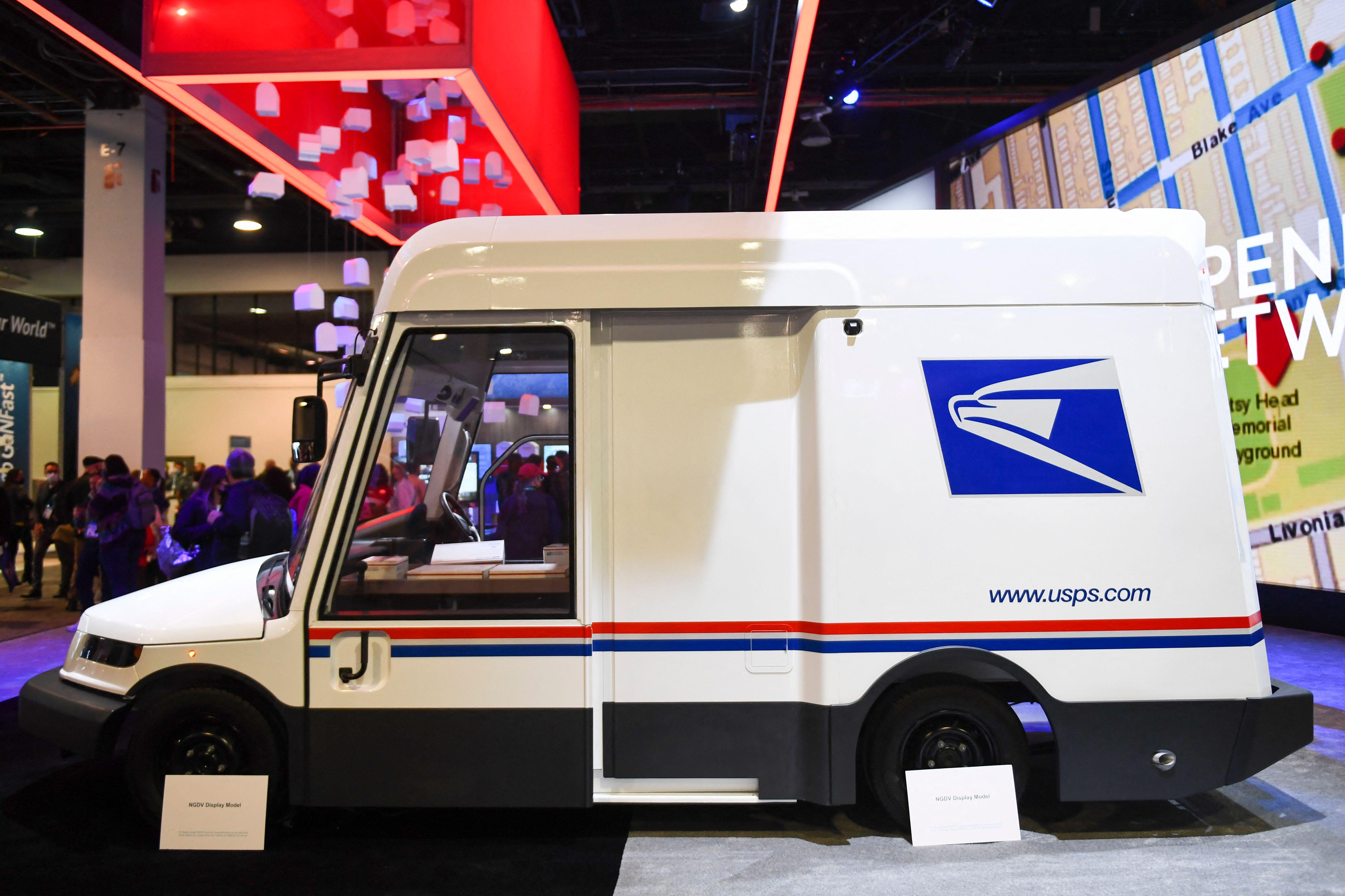 A USPS truck on display on the floor of a trade show