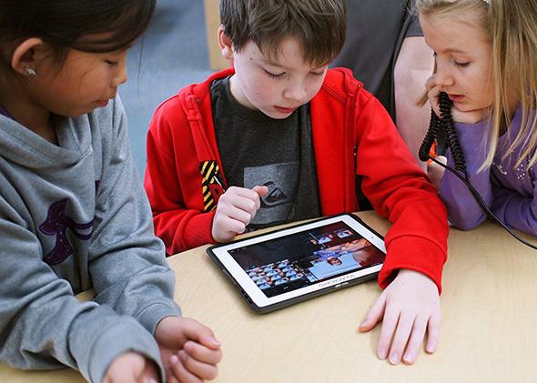 Children use an iPad in the classroom
