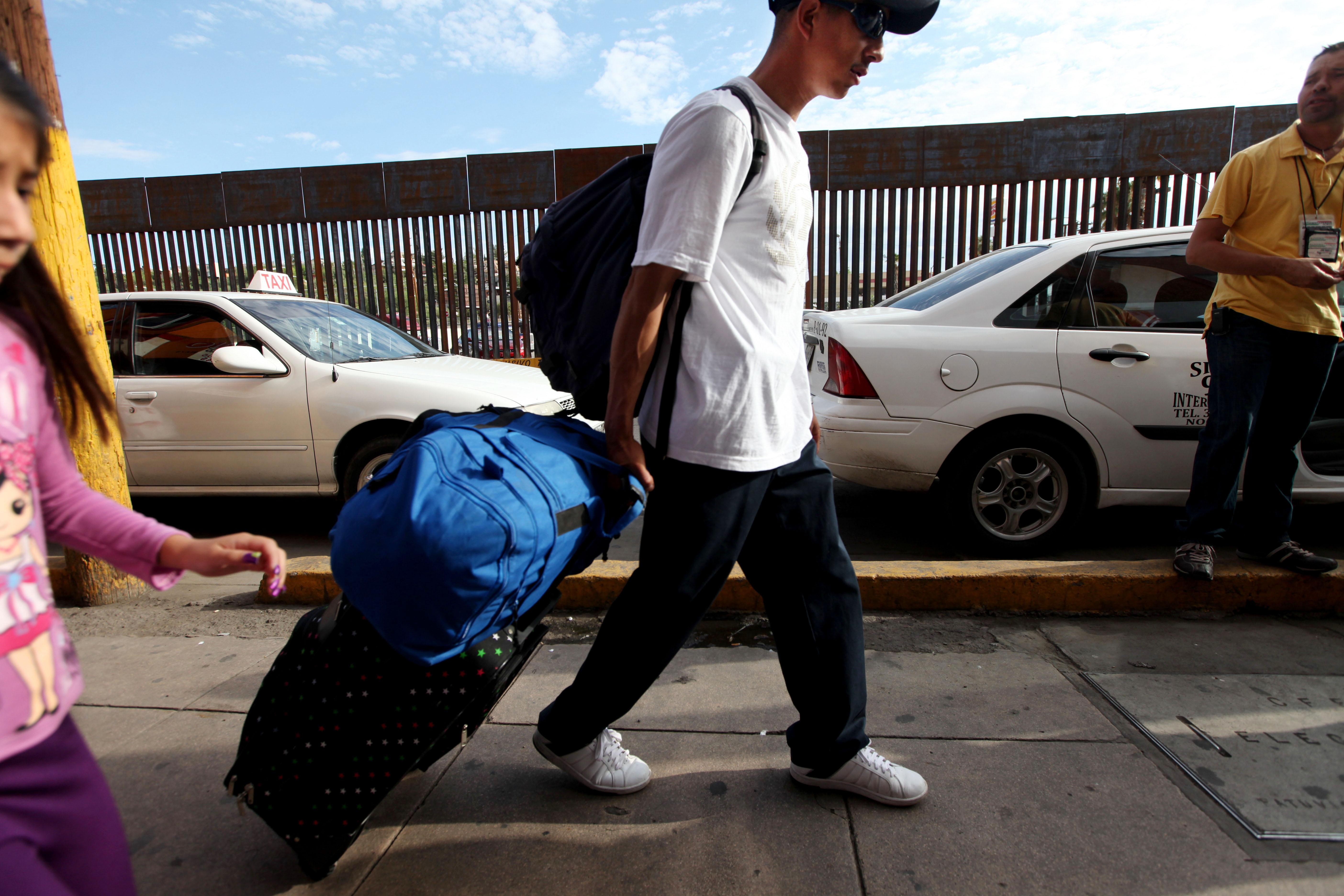 A Mexican national carts his luggage toward the U.S-Mexico border on July 7, 2012, in Nogales, Mexico.