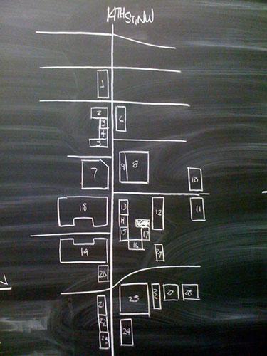 A map of houses along a street on a chalkboard.
