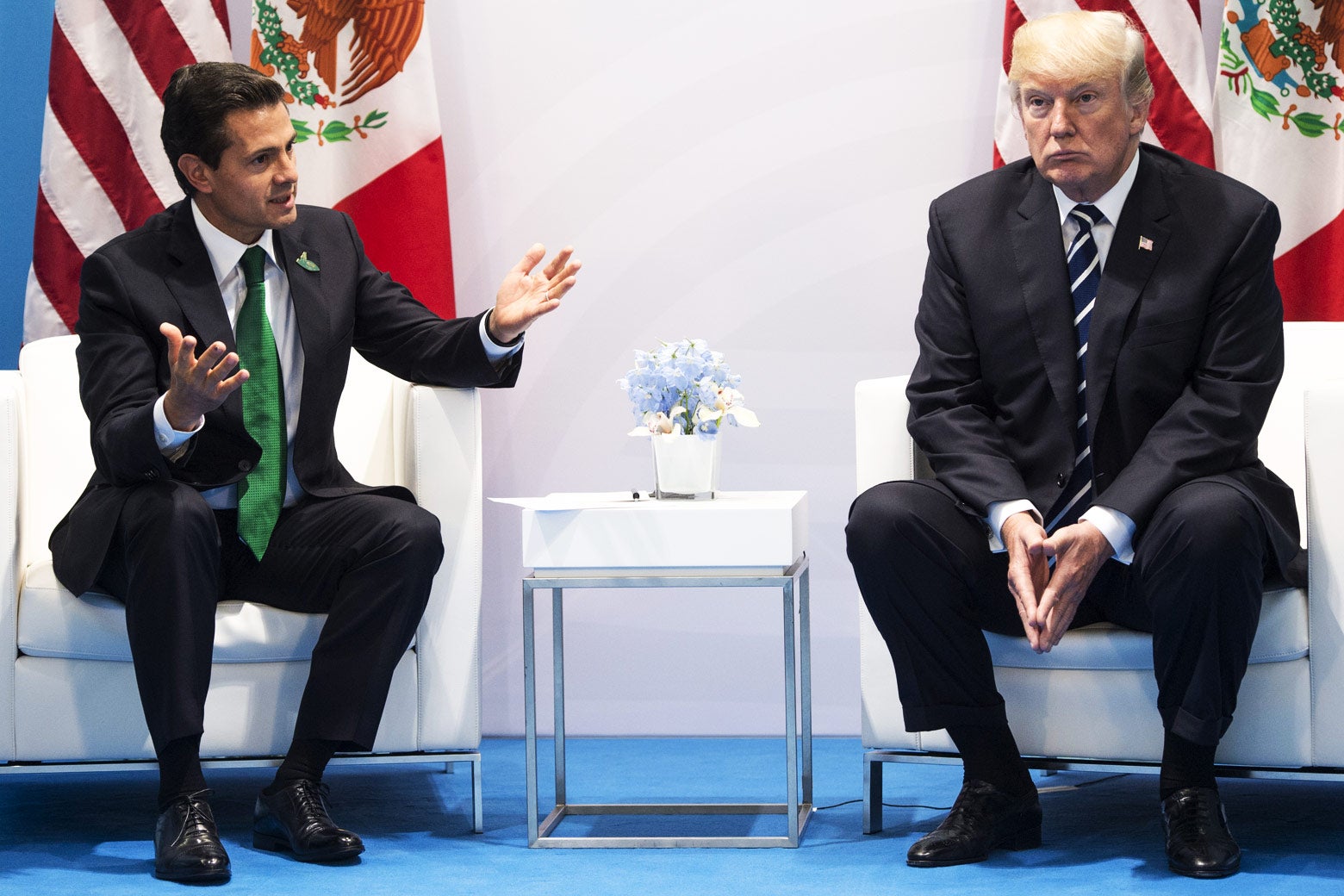 Enrique Peña Nieto and Donald Trump sit beside each other in white armchairs.